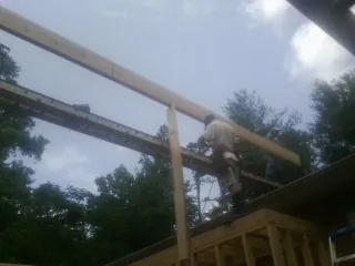 Carpenter setting a ridge beam over a new addition frame — Ice Dam Removal by Roofing Brothers in Granite Bay