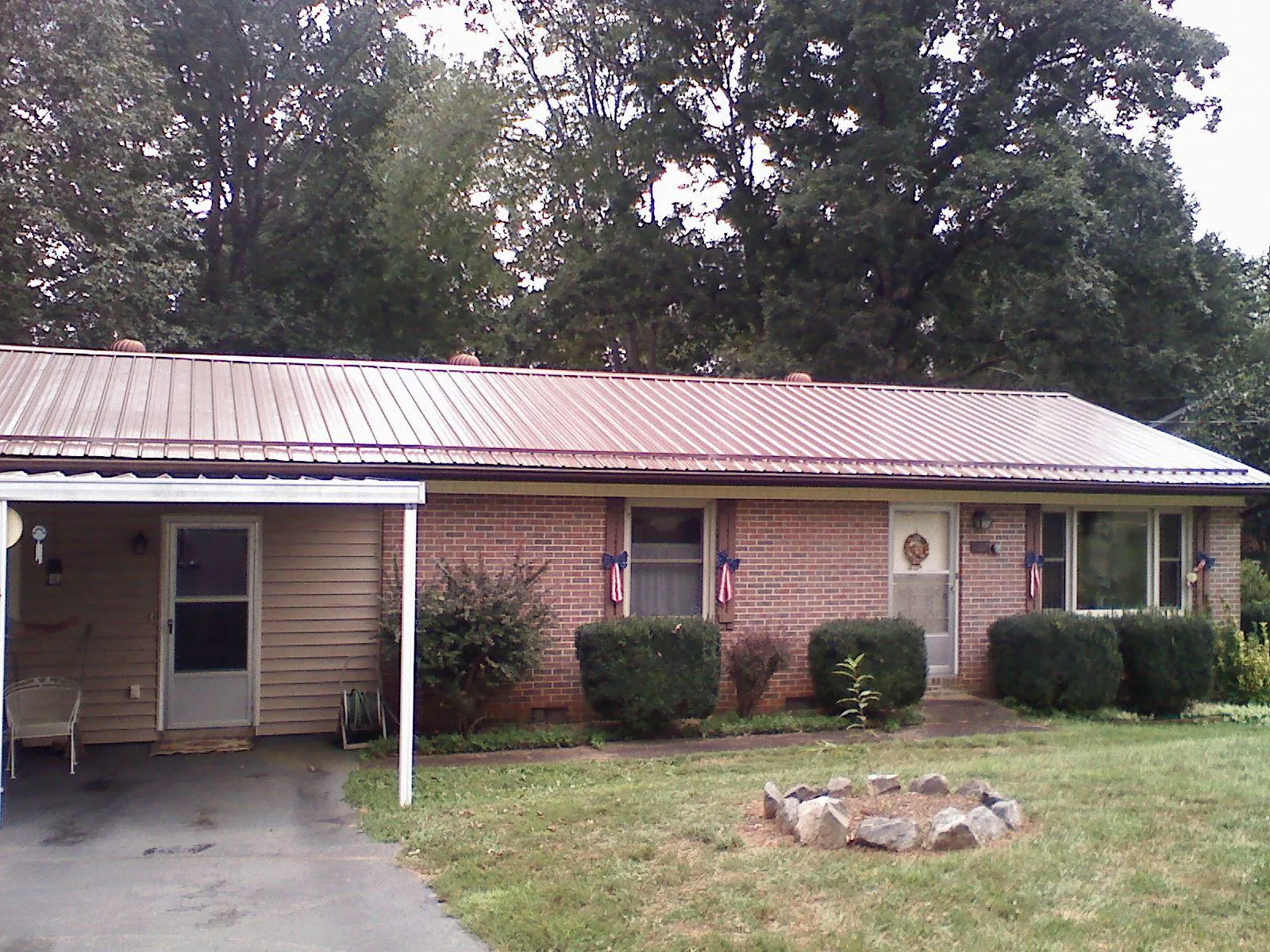 Bronze metal roof and carport on a brick ranch home — Roof Repair work by our crew in Granite Bay